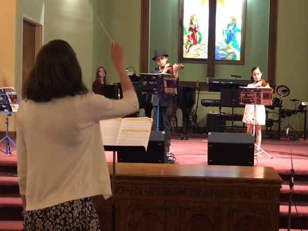 Sarah Aldiab conducting a string recital